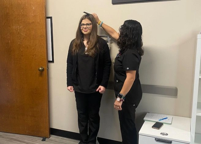 student measuring the height of another student student measuring the height of another student